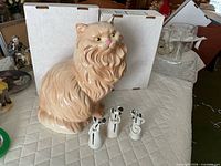 Large glazed ceramic cat and three ceramic mice displayed together