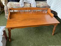 Full view of coffee table front, showing top, spindle back, legs