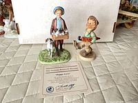 Both figurines and certificate displayed on surface