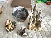 Group shot of three David Winter figurines and cottage scene plate
