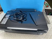 Top view of Epson Stylus CX7450 with power cord and paper support resting on lid