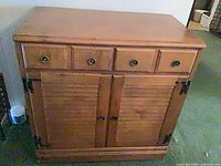 Front view of walnut sideboard showing drawers, doors, hardware