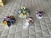 Four floral bone china posies on quilted surface