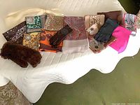 All 11 scarves laid out with 3 glove pairs