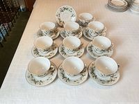Ten teacup and saucer sets arranged on table