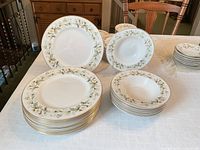 Stacks of dinner plates and rimmed soup bowls on table