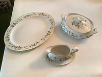 Overall view of platter, covered bowl, gravy boat with underplate