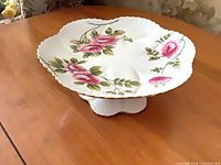 Top view of Shelley Rambler Rose pedestal cake stand showing rose pattern and scalloped gold-trim edge