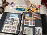 Open binder showing Superman souvenir sheets and assorted mint panes