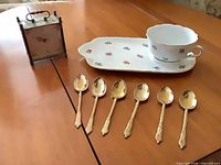 Group shot showing platter, cup, 6 spoons and alarm clock