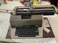Full view of Underwood 700 electric typewriter on table with power cord and paperwork