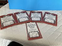 Five red-sleeve items laid out on quilted surface showing map titles and booklet