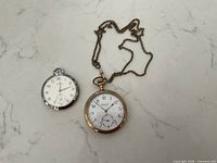 Front view of both watches to show designs and chain