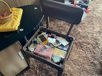 Chair seat lifted showing storage compartment full of sewing notions