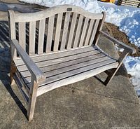 Front angled view of wooden bench showing slatted design and overall condition