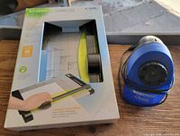 Boxed Carl RT-200N rotary trimmer beside Bostitch QuickSharp sharpener