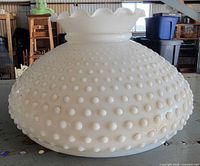 Side view of white hobnail milk glass lampshade with ruffled top
