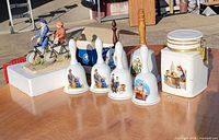 Group shot of figurine, bells and cookie jar on table