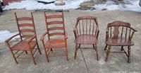 Four different wooden chairs lined up outdoors
