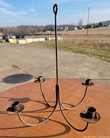 Full view of metal hanging candelabra on table outdoors