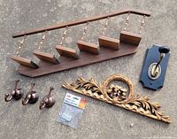 All items laid out: staircase shelf, carved applique, single hook plate, three hooks, binder clips