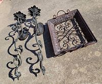 Pair of wrought iron sconces and square tray on ground