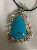 Front view of pendant showing turquoise howlite stone and silver frame