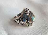 Perspective view of ring showing abalone cabochon and scrollwork band