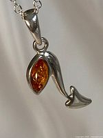 Close-up of silver pendant with amber inset