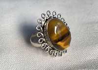 Side view of sterling silver tiger eye ring showing cabochon and filigree