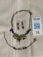 Full view of necklace, earrings pair and bracelet laid out