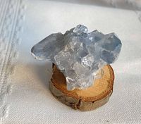 front angle view of celestine cluster on wood slice