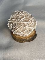 Top angled view of the desert rose gypsum cluster on small wood slice