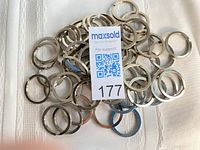 Pile of metal split rings with MaxSold lot tag visible