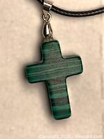 Close-up of malachite cross pendant on cord