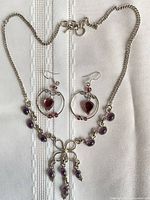 Necklace and earrings laid flat showing overall design and stone colours