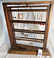Front view of rotating wooden earring rack with earrings displayed