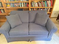 Front view of blue polka-dot loveseat with two cushions and two pillows