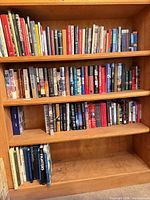 Four shelves filled with mixed hardcovers and paperbacks