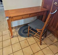 Console table, wooden chair and blue braided rug together