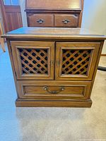 Front view showing lattice cabinet doors and lower drawer