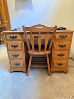 Front view of desk with chair showing drawers and hardware