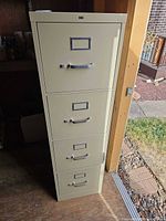 Front view of beige 4-drawer filing cabinet showing handles and overall condition