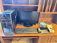 Overall view of HP tower, Samsung monitor, HP keyboard, tape dispenser, Post-it tray, CD spindle, and cable on desk