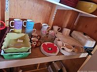 Shelf with mugs, baking dishes, plates, electric skillet
