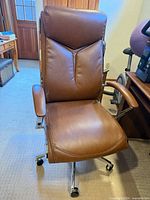 Front view of brown executive chair showing seat, backrest, arms, base