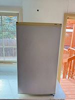 Front view of closed white Sanyo refrigerator