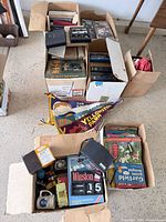 Overview of three boxes containing books, comics, speakers, pennants and other items