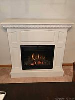 Front view showing white mantel and lit firebox