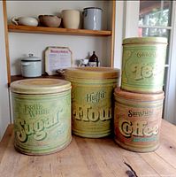 Four vintage canisters on countertop showing size comparison